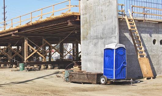 a lineup of sanitized portable toilets on a busy construction site